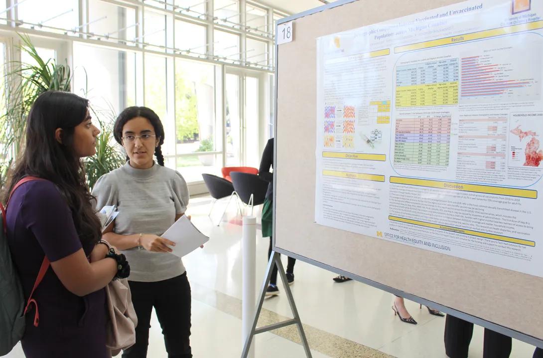 Students discussing an academic poster