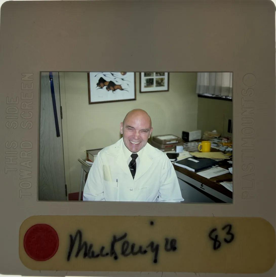 Mackenzie smiling with a white coat on. Photo labelled Mackenzie 83